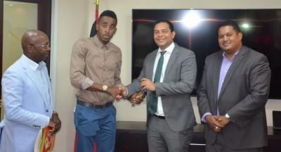 Caption: The Honourable Randall Mitchell, Minister of Housing and Urban Development presents track and field athelete, Jehue Gordon with the keys to his new home. Looking on are: Honourable Darryl Smith, Minister of Sport and Youth Affairs (right) and Mr. Newman George, Chairman, Housing Development Corporation. (Photo courtesy the Ministry of Housing and Urban Development)