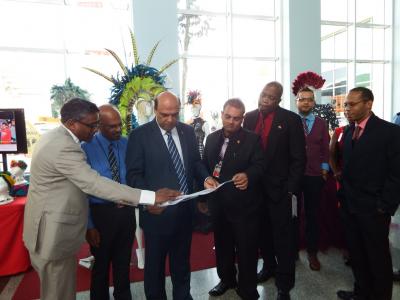 Caption: Tertiary Education and Skills Training Minister, Fazal Karim (centre) reviews plans for aboUTT, the UTT Consignment and Merchandise Store to be established at Piarco International Airport. Looking on (l-r): Dr. Fazal Ali, Provost, UTT, Professor Dyer Narinesingh, President, UTT, Rajiv Dipnarinesingh, Deputy Chairman , Airports Authority of Trinidad & Tobago(AATT), Hayden Newton, General Manager (Ag), AATT, Pranesh Sharma, Senior Business Development Officer, UTT, and Emmanuel Baah, Marketing Manager, AATT. (Photo courtesy the Ministry of Tertiary Education and Skills Training)