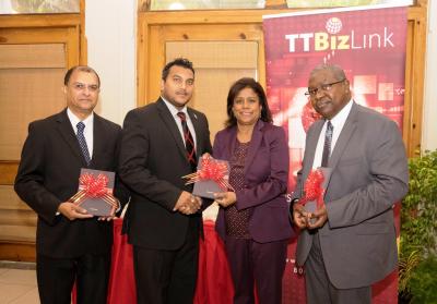 Caption: Senator the Honourable Paula Gopee-Scoon, Minister of Trade and Industry presents Senator Avinash Singh with a tablet device along with Dr. Clive Tilluckdharry, Principal Medical Officer, Ministry of Health (left) and Mr. Theodore Reddock, Executive Director (right). (Photo courtesy the Ministry of Trade and Industry)