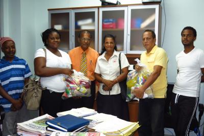 Assistance rendered: Morvant fire victims, Ms George (right) and Ms Lincoln (left) receive their Food Hampers, Temporary Food Card and clothing from Mr Asauph Ghany, Manager of the Main Peoples Issues Resolution Coordinating Unit. (Photo courtesy the Ministry of Social Development and Family Services)