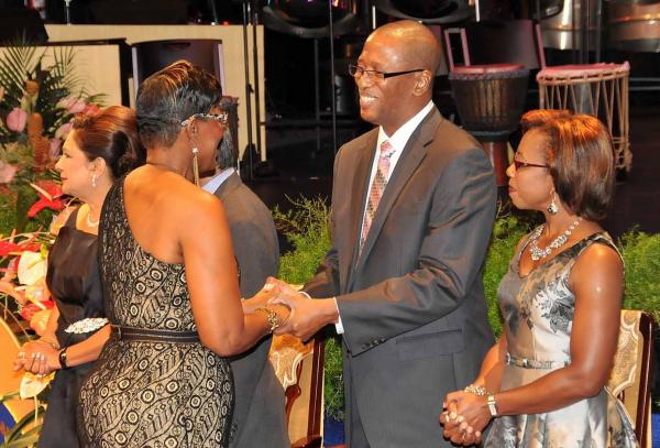 Chief Justice Ivor Archie congratulates Margarete Sampson-Browne, a retired police officer who got the Public Service Medal of Merit (Gold). At right is Mrs. Archie